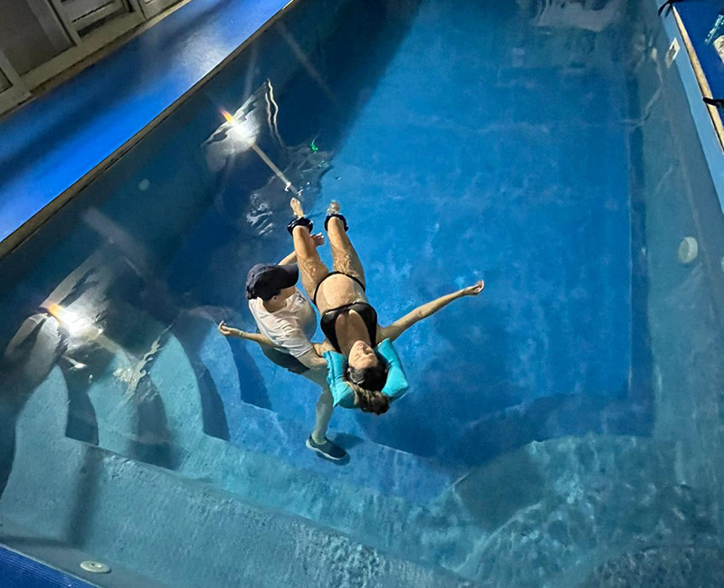 טיפול וואטסו בבריכה עם מטפל תומך במטופלת בתנועה עדינה במים