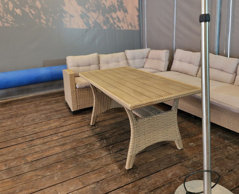 פינת ישיבה נוחה במתחם בריכה עם ספות ושולחן עץ באזור המתנה ומנוחה