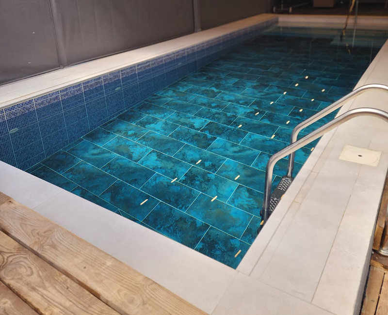 בריכת שחייה מקורה עם סימוני מסלולים ומדרגות כניסה במתחם טיפולים ואימונים