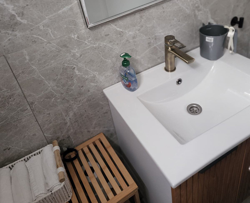 כיור רחצה נקי ומסודר במתחם בריכה עם סבון ידיים ומגבות לשמירה על היגיינה